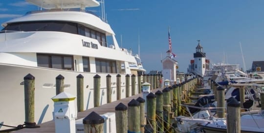 Yacht parked in Saybrook Point Resort & Marina marina with smaller boats parked on the other side of the dock.