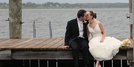 Bride and groom kissing on dock.