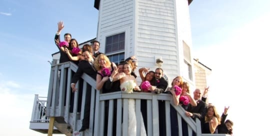 Wedding party posing on stairs of lighthouse.