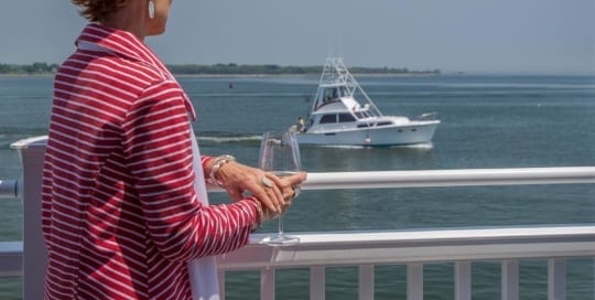 OIder Red Haired Women On Balcony Looking At Boats On The Connecticut River