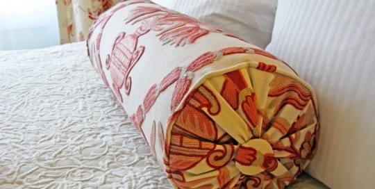 Hotel room bed and pillows.