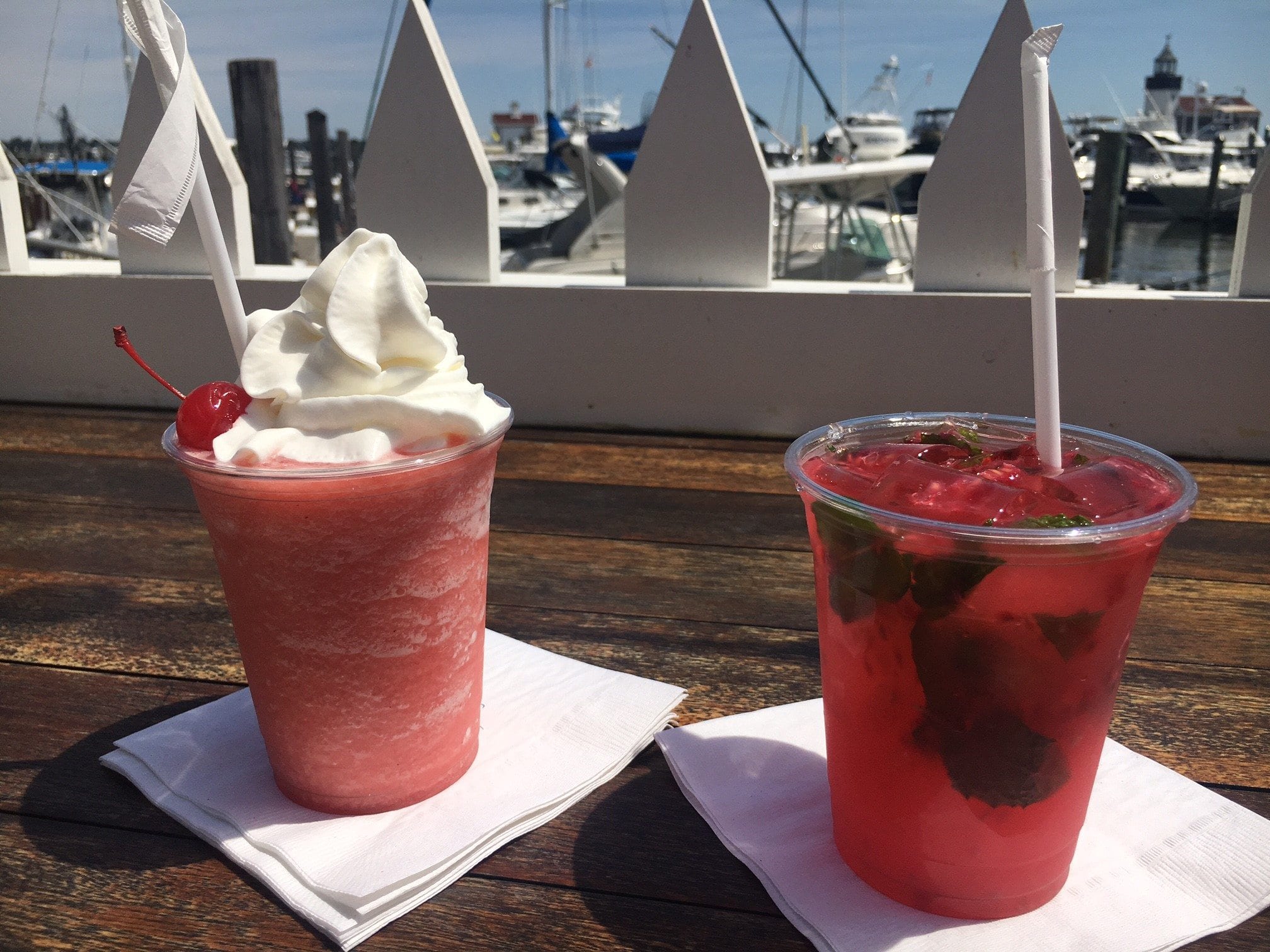 tgif Hand-Crafted Cocktails From The Marina Bar at Saybrook Point Resort & sitting on wooden table near the marina.