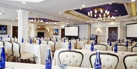Meeting hall setup with tables and chairs.